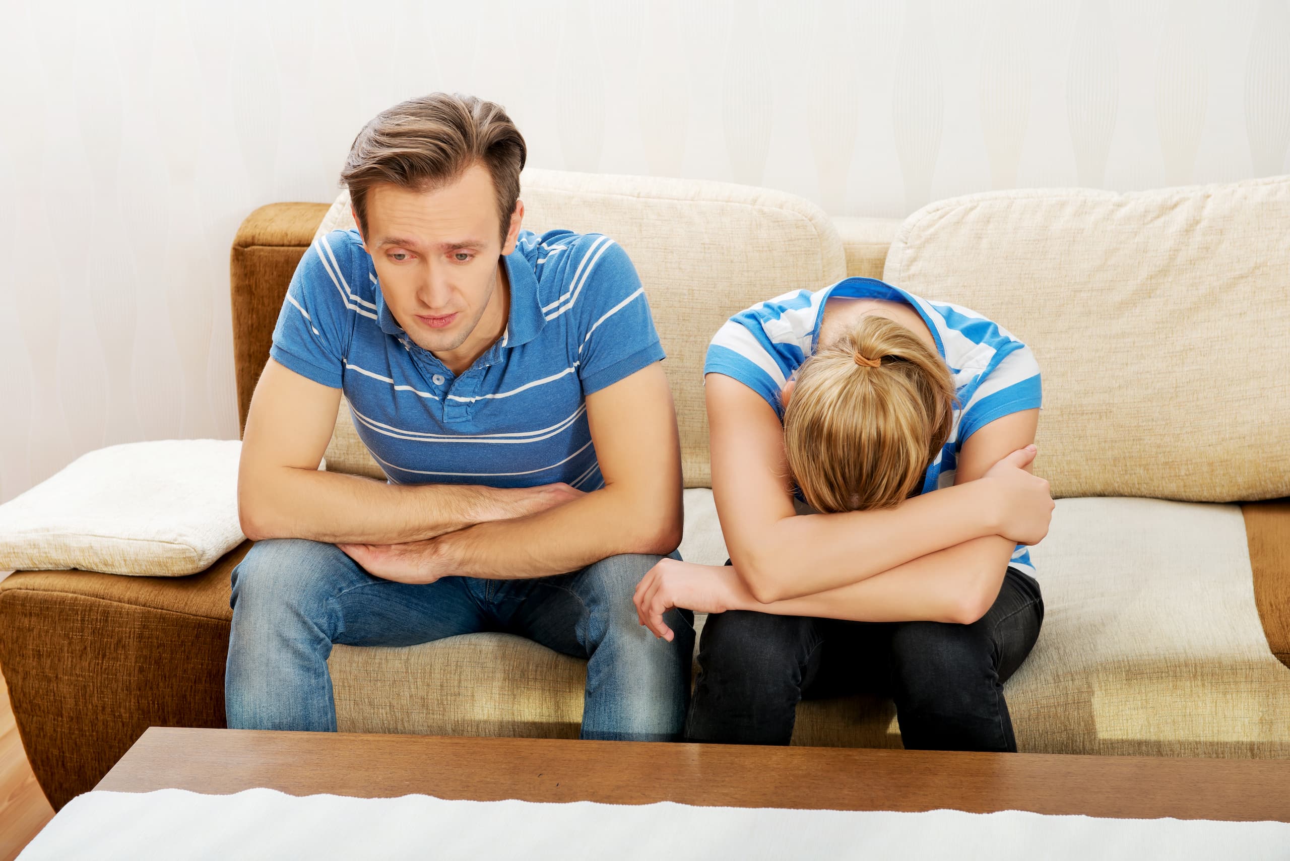 A couple being sad on the sofa.