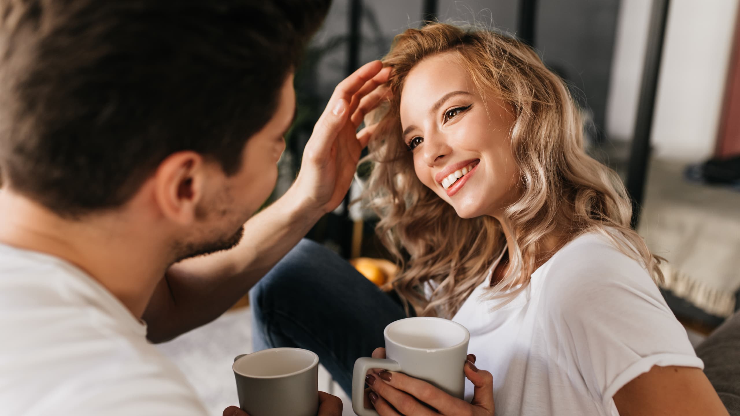 A couple looking at each other while drinking tea.