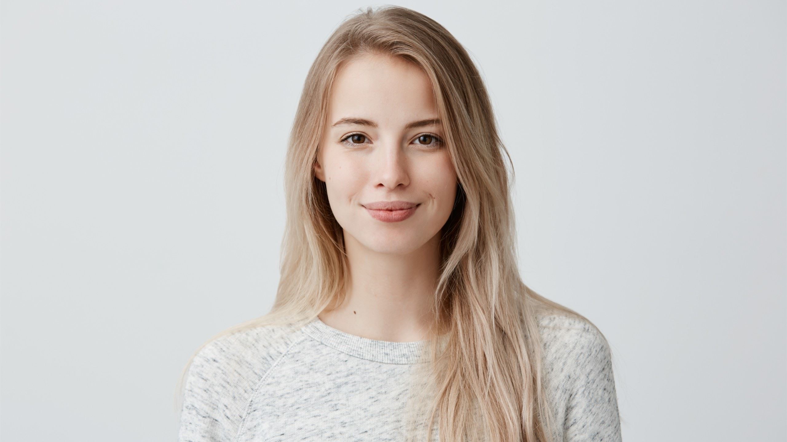 A cute brown-eyed girl is smiling at the camera.