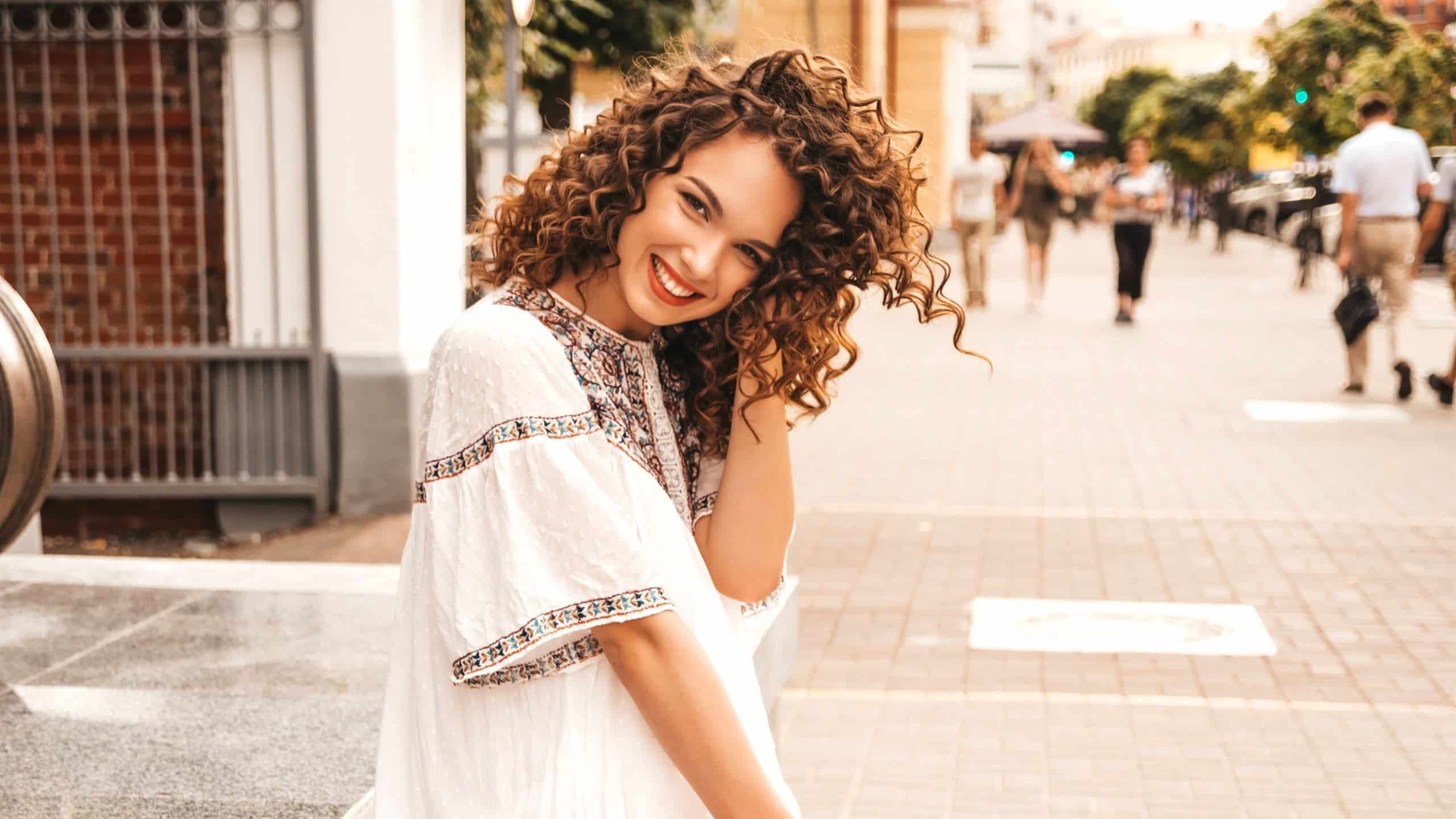 A cute curly-haired girl is smiling.